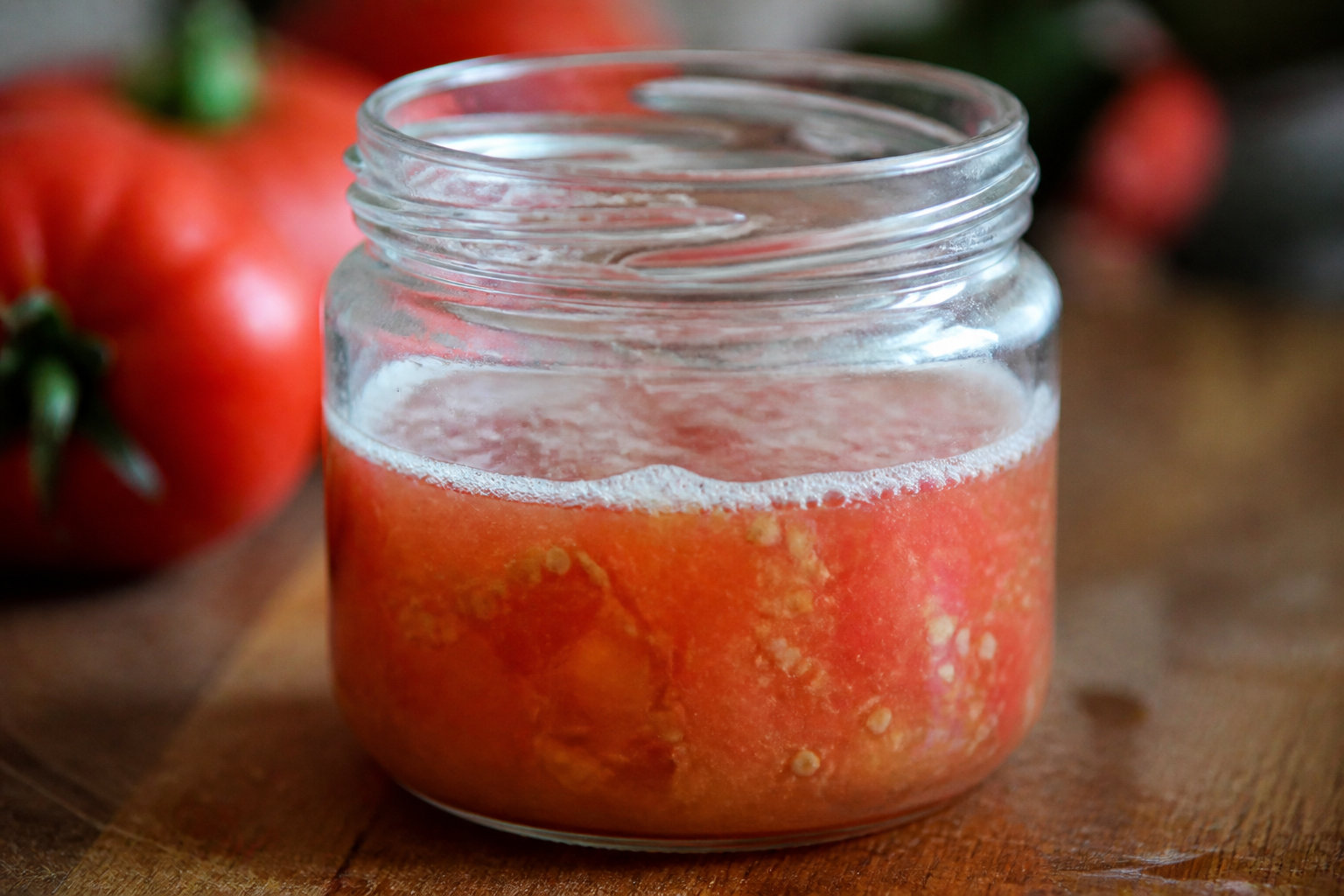 Jus de tomates en cours de fermentation dans un bocal en verre